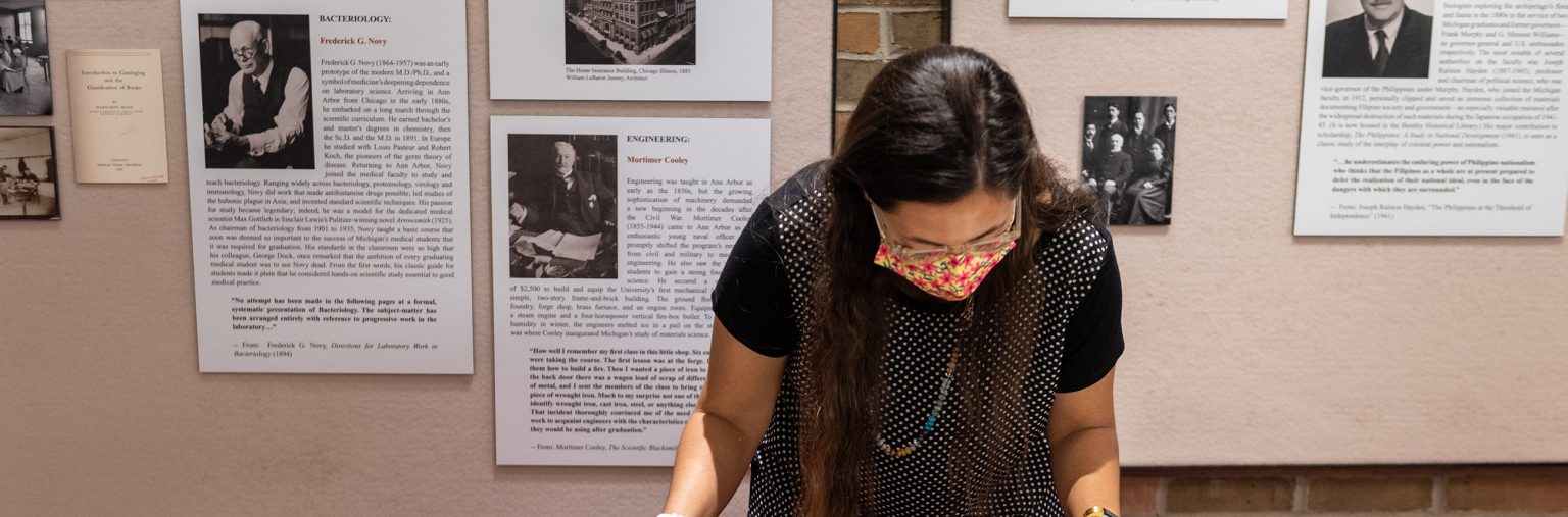 A photo of a Reconnect/Recollect researcher examining archival materials related to the Philippines.