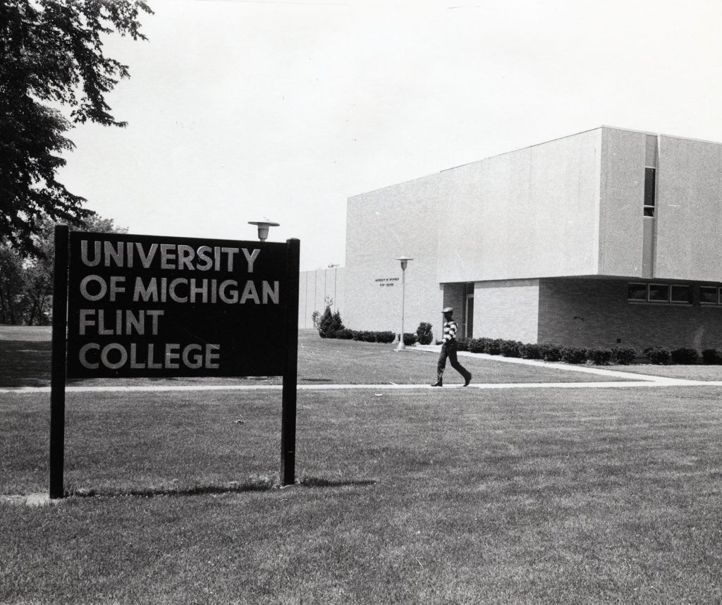 A photo of a young man walking outside U-M Flint College.